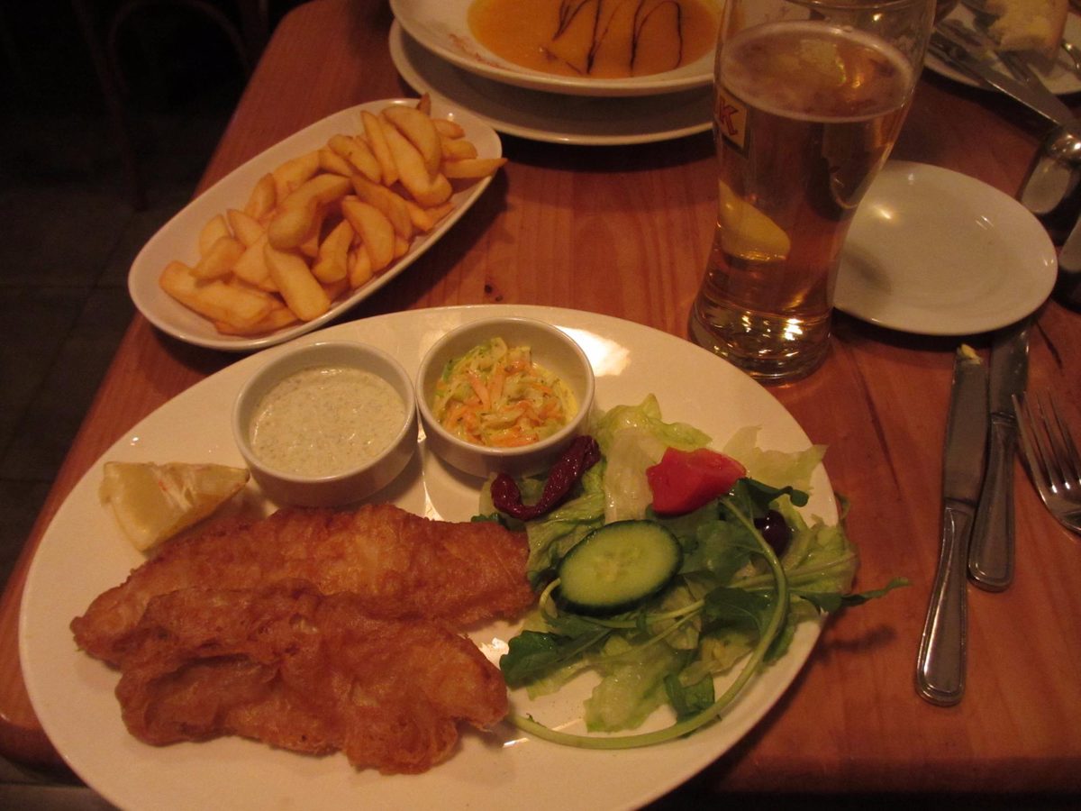 Fish and chips with a beer on a wooden table
